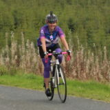 Woman road cycling in Scotland Countryside