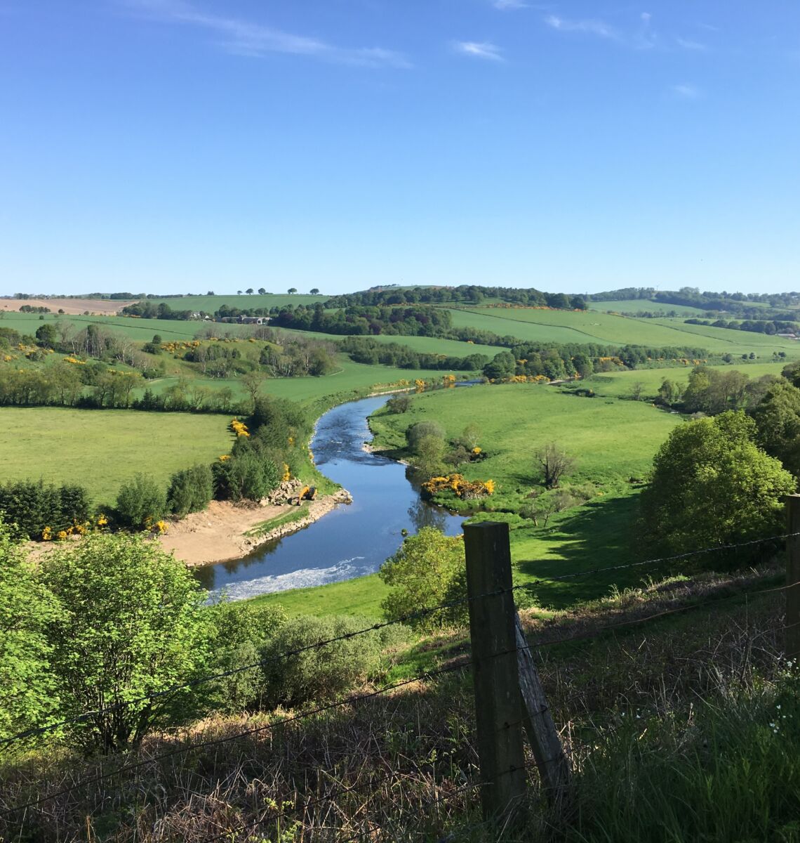 Road bike leaning against fence with River Deveron in background