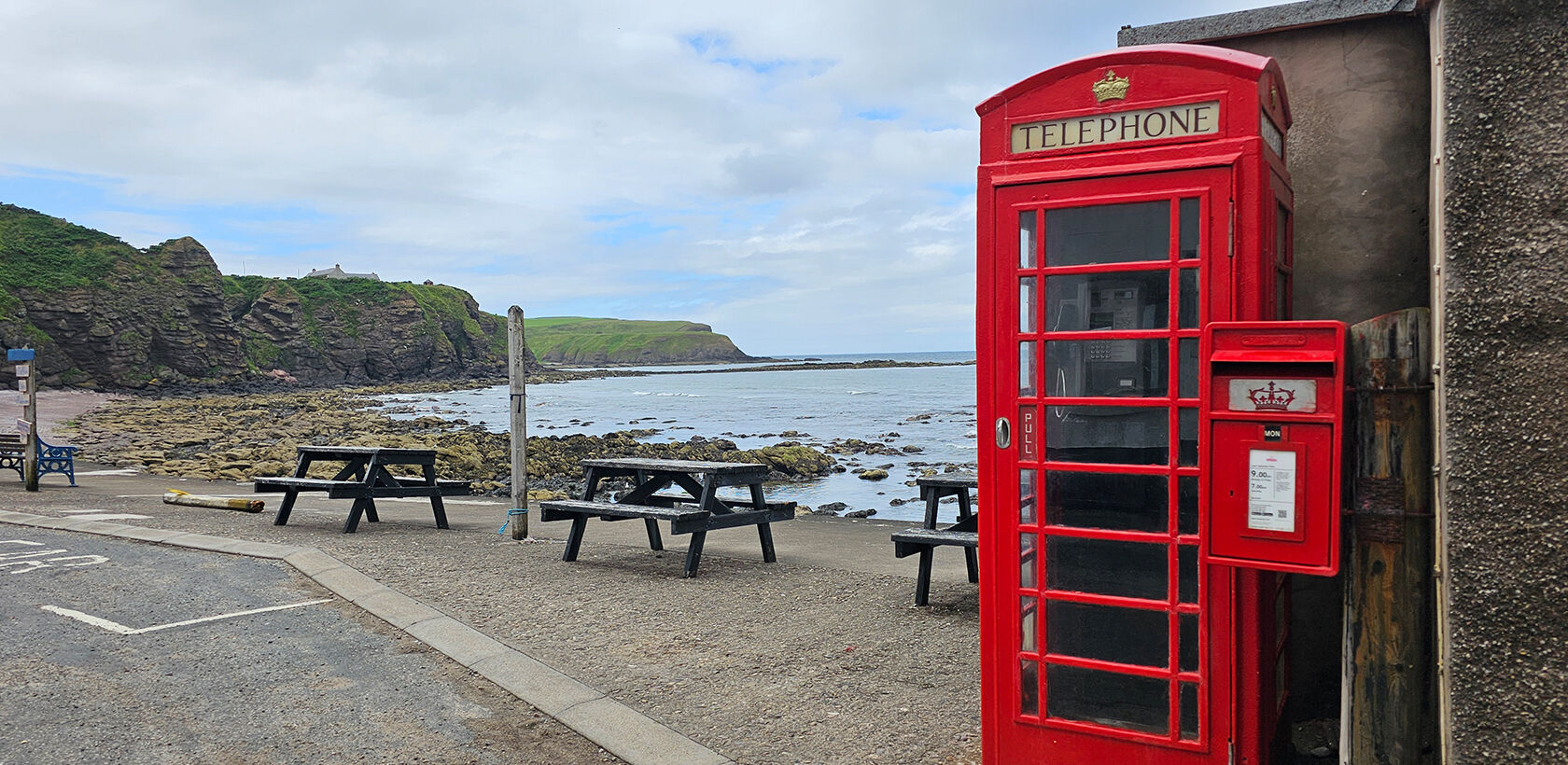 Red phone box next to the sea