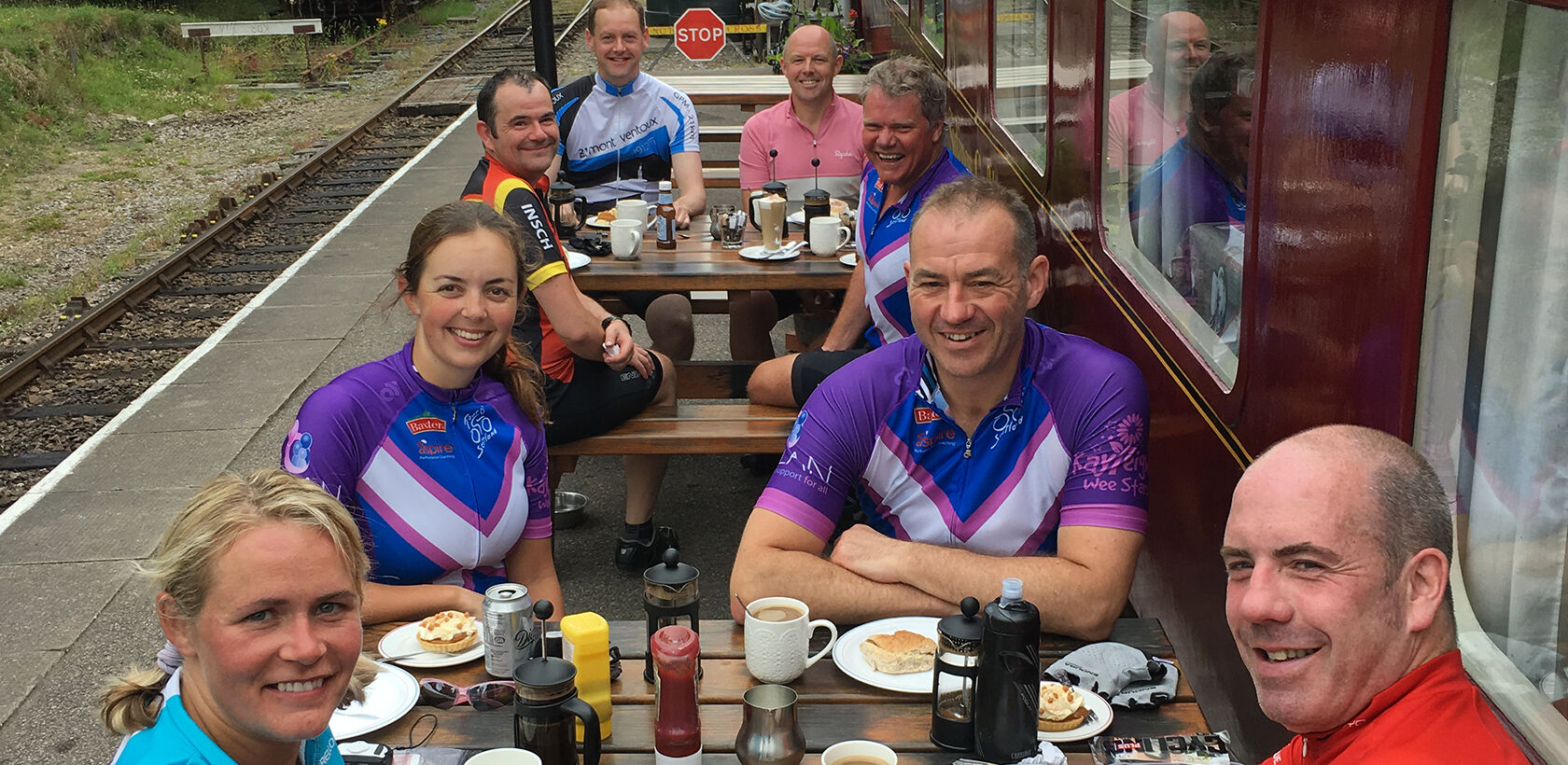 Cyclists sat outside café consisting of converted train carriages