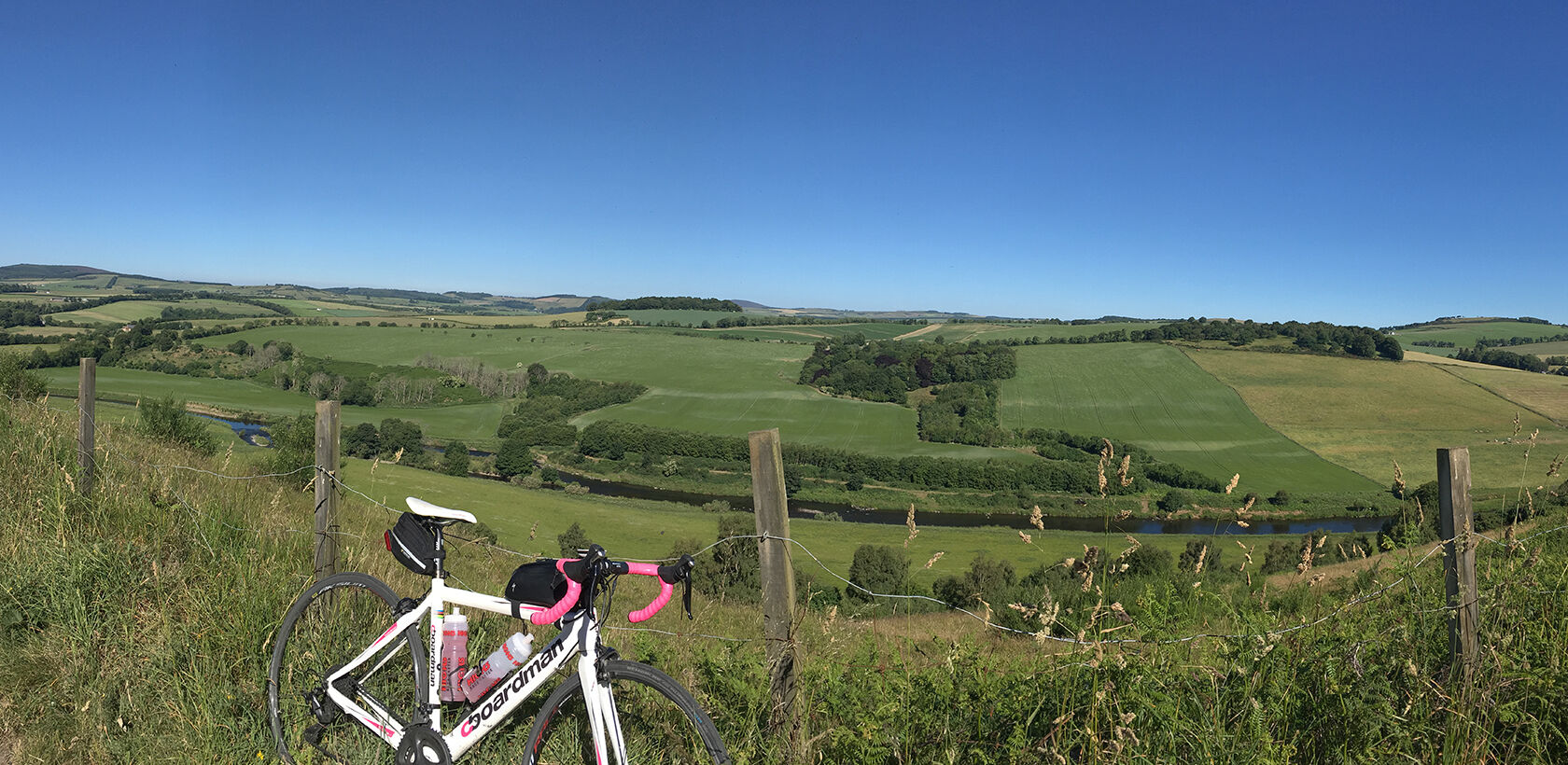 Road bike leaning against fence with River Deveron in background