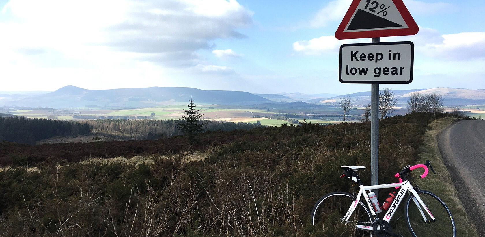 Road bike leaning against bench with view of Bennachie from the top of the Suie Hill